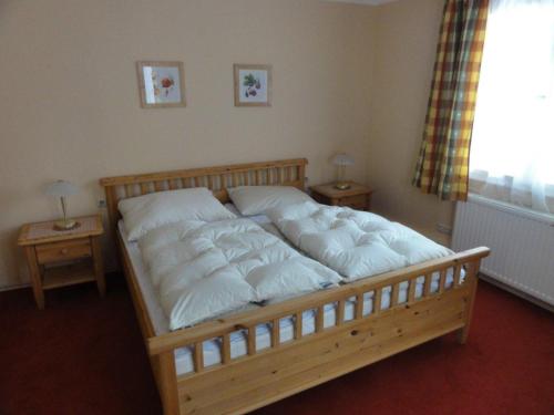 a bed with white pillows on it in a bedroom at Ferienhaus Reith in Bad Mitterndorf