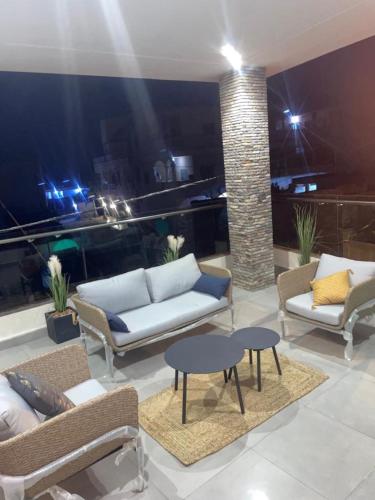 a living room with couches and tables on a balcony at RESIDENCE MH SERVICES Cotonou in Cotonou