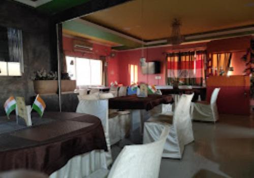 een eetkamer met witte stoelen en een tafel bij Hotel Gitanjali Malda in Māldah