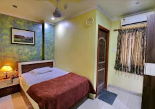 Hotel Gitanjali Malda tesisinde bir odada yatak veya yataklar