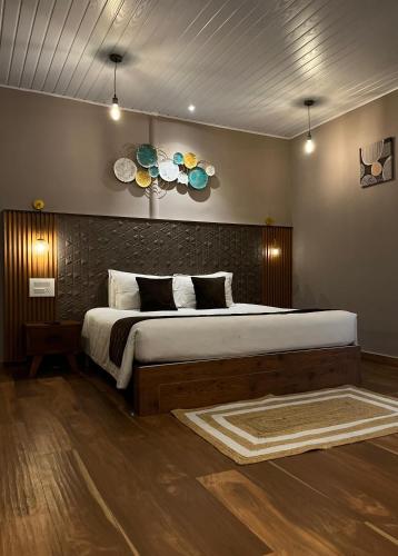 a bedroom with a large bed and two plates on the wall at Misty Courtyard Resort in Chinnakanal
