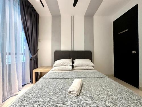 a bedroom with a bed with a towel on it at BNB Cozy Homestay @ Cyberjaya in Cyberjaya