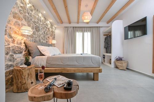 - une chambre avec un lit, une table et une télévision dans l'établissement Naxos Finest Hotel & Villas, à Naxos Chora