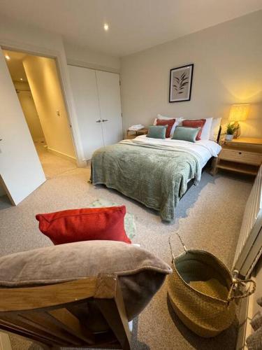 The Jade Suite - The Jewellery Suites, 3 bed 3 bath في برمنغهام: غرفة نوم بسرير كبير وكرسي