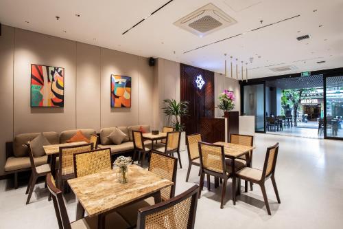 Un restaurante con mesas y sillas y un sofá. en The Dream Suite, en Da Nang