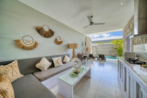a living room with a couch and a table at Bali Cosy Villas Seminyak in Legian