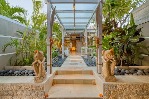 a hallway with two statues in a building at Bali Cosy Villas Seminyak in Legian