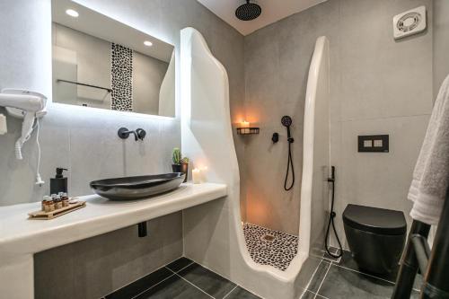 a bathroom with a sink and a shower at Naxos Finest Hotel & Villas in Naxos Chora