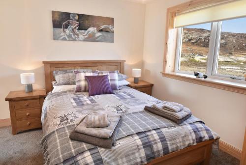 a bedroom with a bed and a window at Rockpool in Pollachar