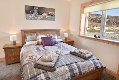 un dormitorio con una cama y una ventana en Rockpool, en Pollachar