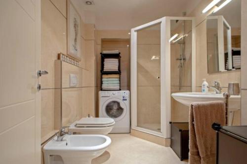 La salle de bains est pourvue de toilettes, d'un lavabo et d'un lave-linge. dans l'établissement Appartamento nuovo 6 posti - Abetone, à Abetone