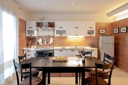 a kitchen with a table and chairs and a kitchen with a refrigerator at Appartamento Centralissimo - Abetone in Abetone