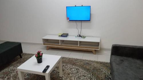 sala de estar con TV y mesa de centro en Umi Homestay, Laman Haris, en Bandar Puncak Alam