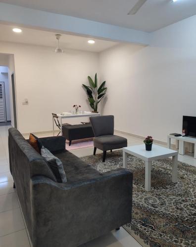 ein Wohnzimmer mit Couch und Tisch in der Unterkunft Umi Homestay, Laman Haris in Bandar Puncak Alam