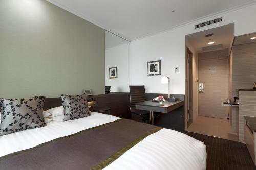 埼玉的住宿－皇宮大宮酒店，酒店客房配有一张床、一张书桌和一间厨房。