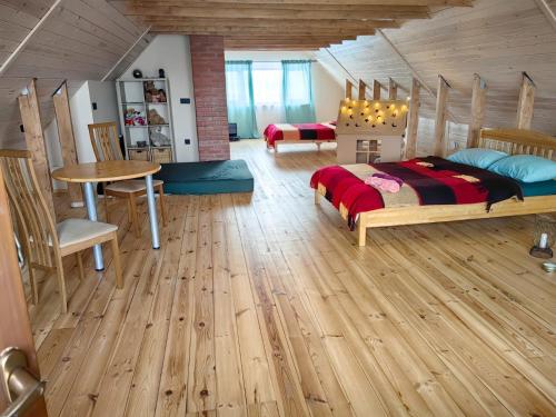 ein Schlafzimmer mit einem Bett und einem Tisch in einem Zimmer in der Unterkunft Zaķu muiža in Anspoki