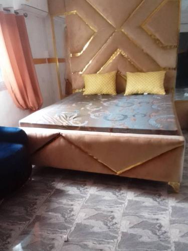 ein großes Bett mit gelben Kissen in einem Zimmer in der Unterkunft NGOME Lounge 