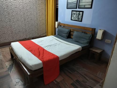 a small bed with a red and white blanket on it at SR HOME STAY in Bhubaneshwar