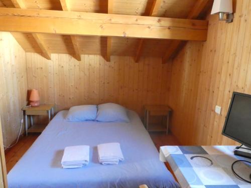 een slaapkamer met een bed met twee handdoeken erop bij Chalet Beaujon Chapelle-des-Bois in Chapelle-des-Bois