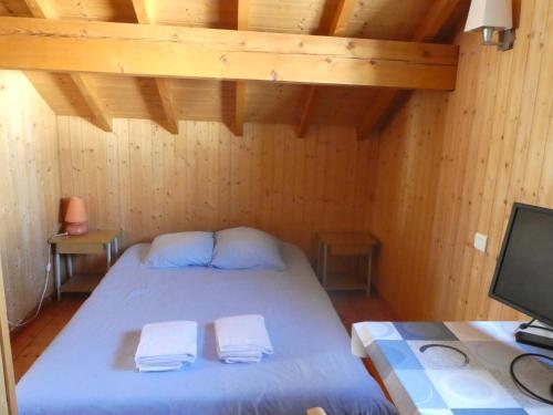 a bedroom with a bed with two towels on it at Chalet Beaujon Chapelle-des-Bois in Chapelle-des-Bois