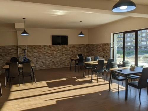 a dining room with tables and chairs and a brick wall at Khando2023 in Gudauri