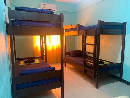two bunk beds in a room with a mirror at Ahras Place in Coron