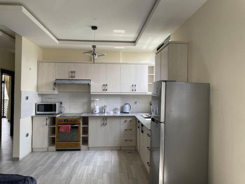 a kitchen with white cabinets and a stainless steel refrigerator at Modern living in Addis Ababa