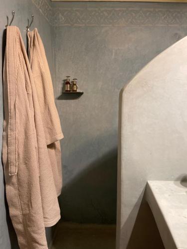 a bathroom with a towel hanging on a wall at RIAD DAR NAOMI in Marrakech