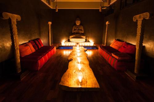 a room with two chairs and a buddha sitting in a room at Fellah Hotel in Marrakech