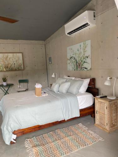 a bedroom with a large white bed with a rug at The Serene House Bed & Breakfast in Luquillo