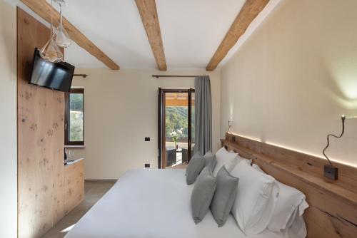 a bedroom with a white bed with a wooden headboard at Sporting Hotel San Felice in Illasi