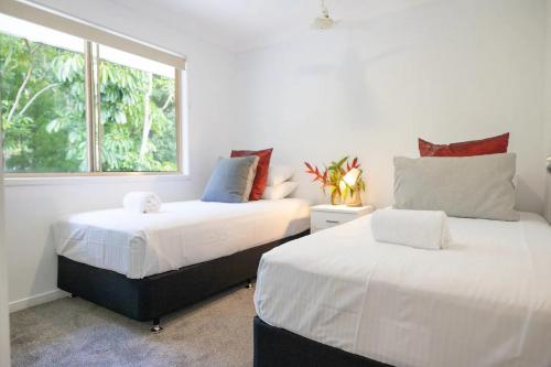 two beds in a room with a window at Byron Lakeside Holiday Apartments in Byron Bay