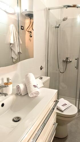 a white bathroom with a shower and a sink at sciuliddA Casa Vacanze in Avola