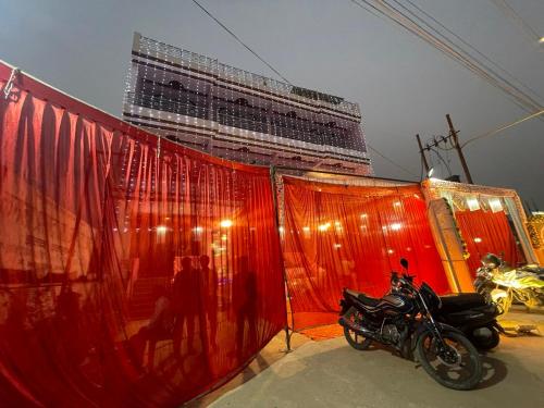 una motocicleta estacionada frente a un gran edificio en Divine INN hotel and guest house, en Bamrauli