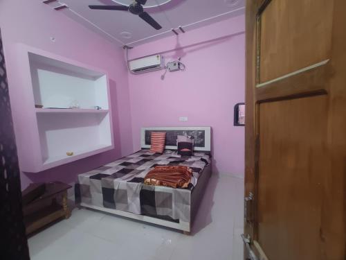 een slaapkamer met een bed met paarse muren en een plafond bij Divine INN hotel and guest house in Bamrauli