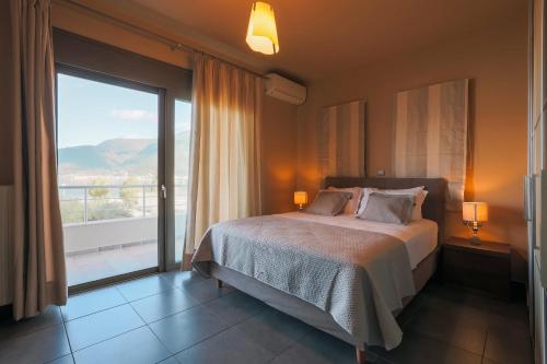 a bedroom with a bed and a large window at Malena in Karavomylos
