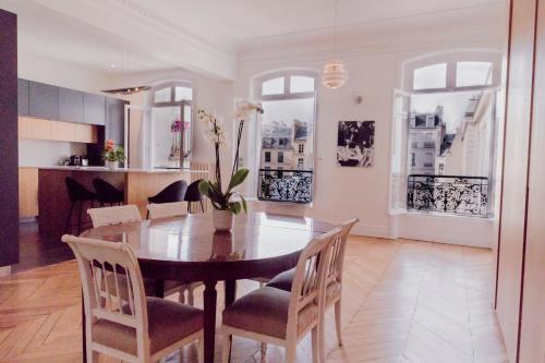 une cuisine et une salle à manger avec une table et des chaises dans l'établissement Luxueux duplex Elysées 240m2, à Paris