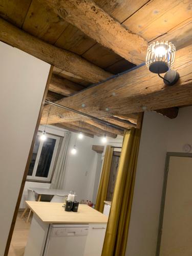 una cocina con techos de madera y una lámpara. en Le Chapard, en Chaponost