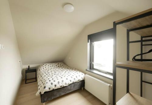 Habitación pequeña con cama y ventana en Dijkwoning 7 personen Yerseke Zeeland, en Yerseke