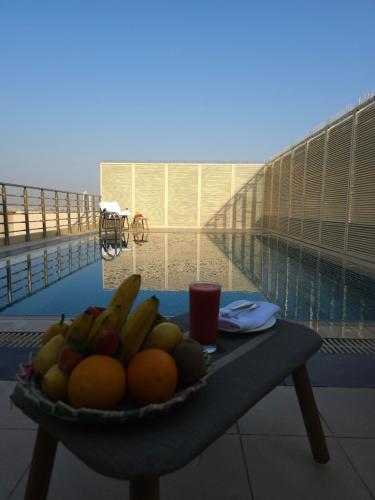 a plate of fruit on a table on a balcony at Jiwar Hotel in Jeddah