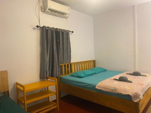 1 dormitorio con 1 cama, ventilador y silla en Sunset Homestay by Harry & Mimin, en Telaga