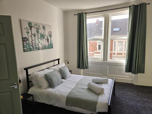 1 dormitorio con cama con almohadas y ventana en Rectory5 - 5 bedroom 7 beds Parking Perfect for Contractors, en Gateshead