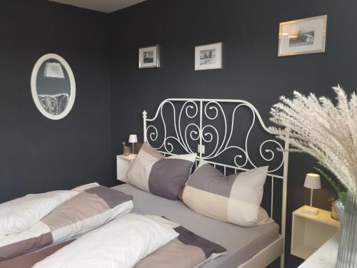 a bedroom with two beds and a black wall at Ferienwohnung Hilderser Auszeit in Hilders