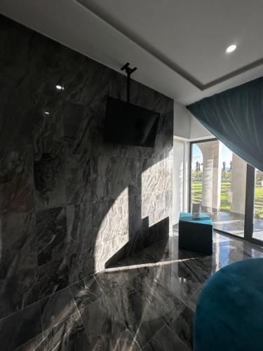 sala de estar con pared de piedra y TV en Luxury Resort, en Licola