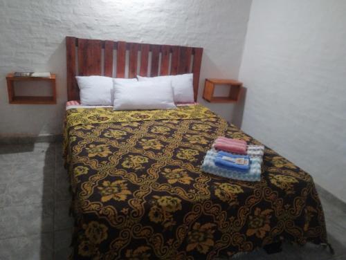 1 dormitorio con cama con colcha y almohadas en Armonia un lugar para Descansar en Formosa