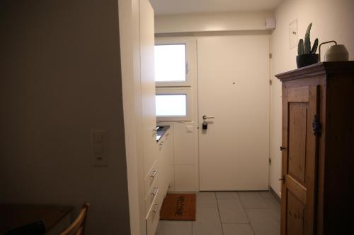 un couloir blanc avec une porte et une fenêtre dans l'établissement Piccolo, à Zurich