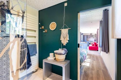 a room with a green wall with a table and a door at Tinyhouses - Domain "La vallée des Prés" in Bande