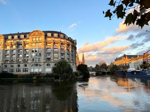 a building next to a river next to a building at Magnifique appart côté Cathédrale in Strasbourg