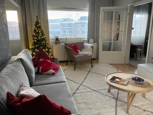 ein Wohnzimmer mit einem Weihnachtsbaum und einer Couch in der Unterkunft Peaceful City Centre Apartment (2 Bdr) in Rovaniemi