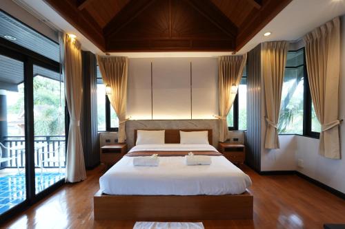 - une chambre avec un lit doté de draps blancs et de fenêtres dans l'établissement รมิดา พูล วิลล่า พัทยา Ramida Pool Villa Pattaya, à Jomtien Beach